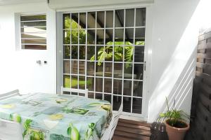 un letto su un portico accanto a una porta di Bungalow charmant au Robert + piscine a Le Robert