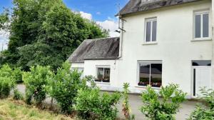 a white house with bushes in front of it at Maison cosy à Pontorson avec jardin clos et terrasse in Pontorson