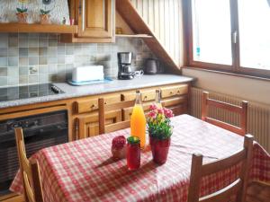 a kitchen with a table with a bottle and flowers on it at Appartement charmant à Thannenkirch avec vue montagne in Thannenkirch