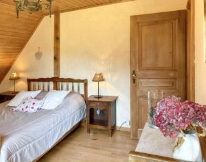 a bedroom with a bed and a table with flowers at Appartement charmant à Thannenkirch avec vue montagne in Thannenkirch