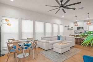ein Wohnzimmer mit einer Couch und einem Tisch und Stühlen in der Unterkunft Latitude Adjustment Walk to Beach Newly Built in Padre Island