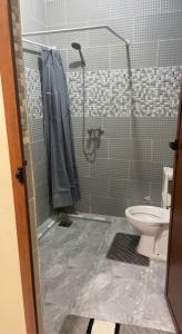 a bathroom with a shower and a toilet at residence rose des sables in Dakhla +9 photos