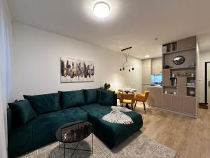 a living room with a green couch and a kitchen at Nuppu1, free parking, self check-in in Trnávka