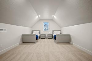 una camera mansardata con due letti e una finestra di Eden Empire with Hot Tub and Game Room Wkly Disc a Eden