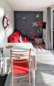 a dining room with a white table and red chairs at Charmante maison de campagne à La Bouillie avec jardinB in La Bouillie