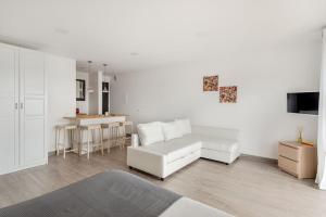 Una sala de estar con un sofá blanco y una mesa. en Estúdio 21 em Santa Bárbara de Nexe - Faro, en Santa Bárbara de Nexe