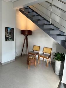 a room with two chairs and a staircase at Condomínio Smv in Barra Velha