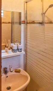 a white bathroom with a sink and a shower at Maison charmante avec vue sur la mer et la montagne à Trois-Rivières in Trois-Rivières