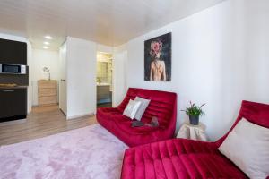 uma sala de estar com uma cadeira vermelha e um sofá vermelho em Apartment Kandahar 42 em Crans-Montana mais 14 fotografias