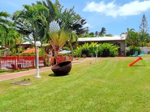 Un jardín con un gran cuenco en el medio de un patio. en Maison intime à Plessis Nogent avec piscine partagée, en Sainte-Rose
