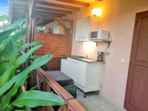 Una pequeña cocina con fregadero y microondas. en Maison intime à Plessis Nogent avec piscine partagée, en Sainte-Rose 3 fotos más