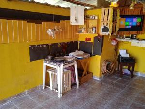 a kitchen with a stove and a yellow wall at casa aconchegante e completa in Mongaguá