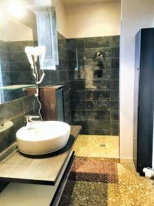 ein Badezimmer mit einem weißen Waschbecken und einer Dusche in der Unterkunft Maison charmante au cœur de Puy-l'Évêque avec piscine partagée in Puy-lʼÉvêque + 13 Fotos