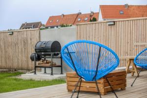 Dos sillas azules sentadas en una terraza con parrilla. en La Vigie, maison face à la Canche, en Étaples