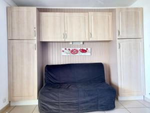a bean bag chair in a room with wooden cabinets at Appartement cosy à Canet-en-Roussillon de 25 m² avec terrasse in Canet-en-Roussillon +9 photos