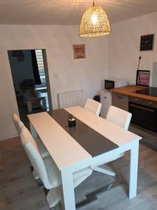 a white table and chairs in a kitchen at Le gîte du puits in Brigueuil +4 photos