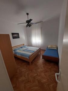 a bedroom with two beds and a ceiling fan at Apartments Margareta in Novigrad Istria