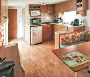 Una cocina con gabinetes de madera y un refrigerador blanco. en Bungalow charmant à Saint-Pierre-d'Oléron avec jardin clôturé, en Saint-Pierre-dʼOléron