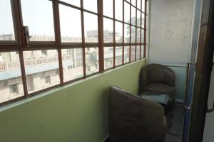 a chair sitting in a room with a window at Classy5 Guest House in Varanasi