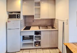 a kitchen with a white refrigerator and a sink at Studio charmant à Hyères, 20 m², jardin et parking privé in Hyères +4 photos