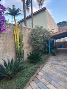 アチバイアにあるRecanto Aparecida lazer, piscina climatizadaの塀と植物のある家