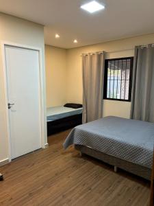 アチバイアにあるRecanto Aparecida lazer, piscina climatizadaのベッドと窓とドアのある寝室