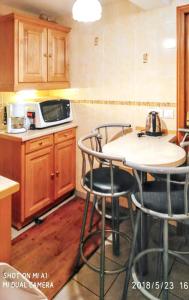 kuchnia ze stołem, krzesłami i kuchenką mikrofalową w obiekcie Appartement cosy à Alfortville - 30 m² - Jardin privé w mieście Alfortville