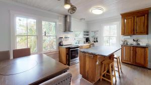 a kitchen with wooden cabinets and a wooden table at Renovated Lemon Guesthouse 4 KING Bedrooms Downtown Half Mile Stroll- Beach Only 3 Miles in Saint Augustine