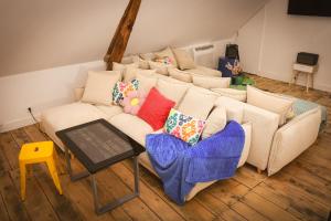 a living room with a white couch with colorful pillows at Magnifique Loft Festif in Saint-Pourçain-sur-Sioule