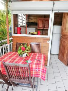 a table and chairs on a porch with a kitchen at Studio accueillant à Sainte-Luce, 30 m² avec jardin privé in Sainte-Luce