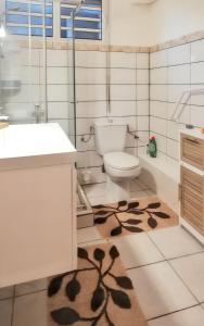 a bathroom with a toilet and a sink and a rug at Studio accueillant à Sainte-Luce, 30 m² avec jardin privé in Sainte-Luce