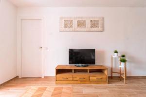 a living room with a tv and a wooden coffee table at Cozy apartment in Playa de la Américas, 60 m² with pool in Playa de las Americas