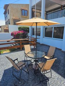 un tavolo e sedie con un ombrellone in un patio di Alto Mar la Lisera ad Arica
