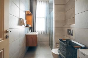 Un baño con lavabo, inodoro y ventana. en Galata Guest Teori, en Estambul 24 fotos más