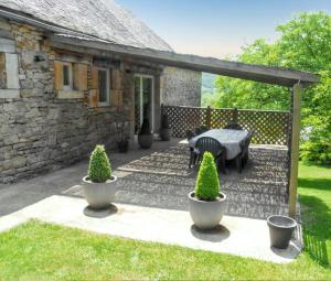 eine Terrasse vor einem Steinhaus in der Unterkunft Maison de caractère à Pierrefiche avec piscine privée in Pierrefiche