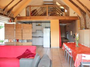 ein Wohnzimmer mit einem roten Sofa und einem Tisch in der Unterkunft Maison de caractère à Pierrefiche avec piscine privée in Pierrefiche + 5 Fotos