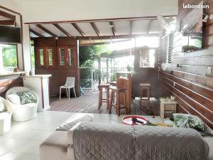 un salon avec un canapé et une terrasse en bois dans l'établissement Maison spacieuse à Pointe-Noire avec piscine partagée 110 m², à Pointe-Noire
