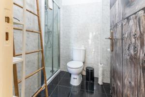 a bathroom with a toilet and a glass shower at Alfama Santa Apolonia Apartment in Lisbon +30 photos
