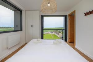 Un dormitorio con una cama y una ventana grande. en La Vigie, maison face à la Canche, en Étaples
