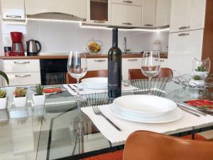 a dining table with a bottle of wine and glasses at Welcoming apartment in Novigrad, 40 m² with peaceful garden in Novigrad Istria