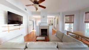 a living room with a white couch and a fireplace at Historic Lady Renovated-Half Mile Walk to DT-Beach 3 Mi-Optional Guesthouse in Saint Augustine