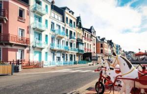 a horse drawn carriage on a city street with buildings at Le Quai 2 Somme in Abbeville