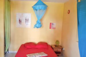 ラ・トリニテにあるStudio charmant La Trinité 20 m² + jardinのベッドルーム1室(赤いベッド1台、壁に青い凧付) +3枚の写真