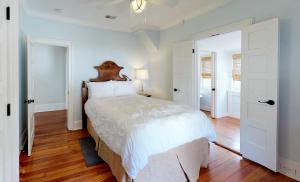 a bedroom with a large bed with a wooden headboard at Historic Lady Renovated-Half Mile Walk to DT-Beach 3 Mi-Optional Guesthouse in Saint Augustine