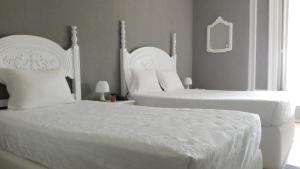 a hotel room with two beds and two lamps at Royal Porto City in Porto