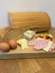 a wooden cutting board with bread eggs cheese and vegetables at Dančí zátiší in Nový Oldřichov +11 photos