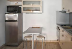 una cucina con un tavolino e due sgabelli di Maison charmante à Saint-Cyprien avec jardin et terrasse a Saint-Cyprien Altre 7 foto