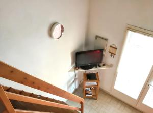 una camera da letto con un letto e una televisione su una parete di Maison charmante à Saint-Cyprien avec jardin et terrasse a Saint-Cyprien