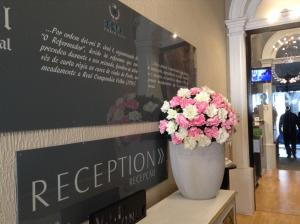 un jarrón de flores sentado en una mesa en una tienda en Royal Porto City, en Oporto