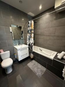 a bathroom with a toilet and a tub and a sink at Cosy studio Beaubourg paris centre in Paris +3 photos